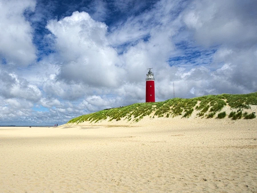 Vuurtoren van Texel achter de duinen en het strand